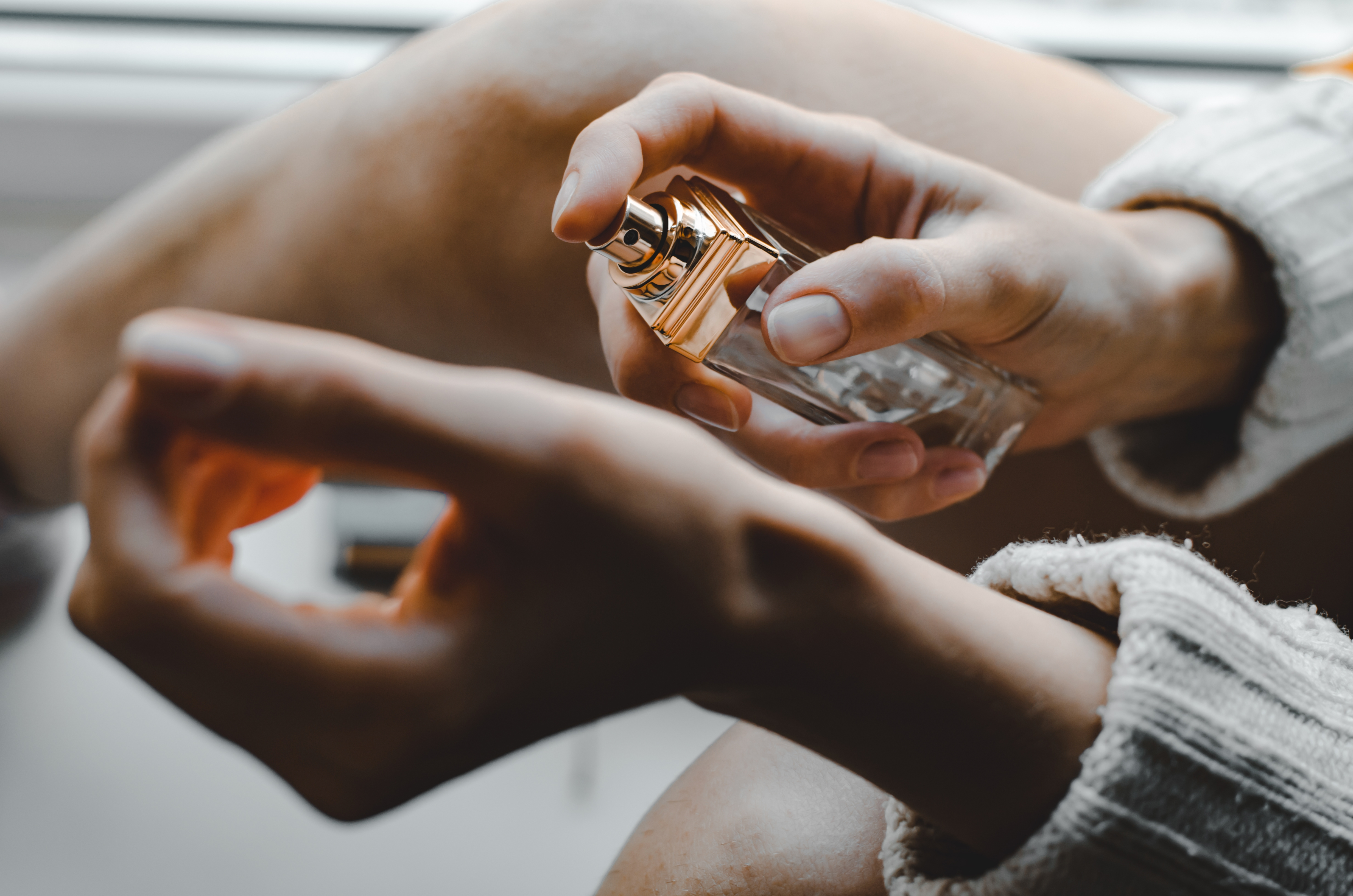 kobieta aplikująca perfumy z ogonem